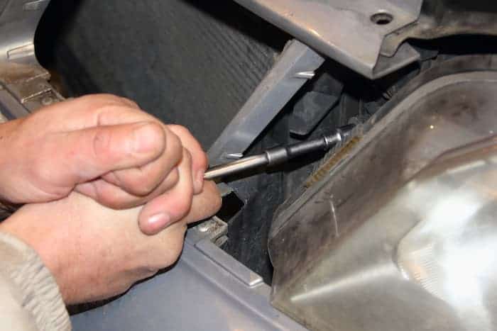 Remove the bolts above the headlight with a socket wrench